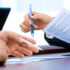 Two people comparing a business quotation before choosing an office photocopier supplier.