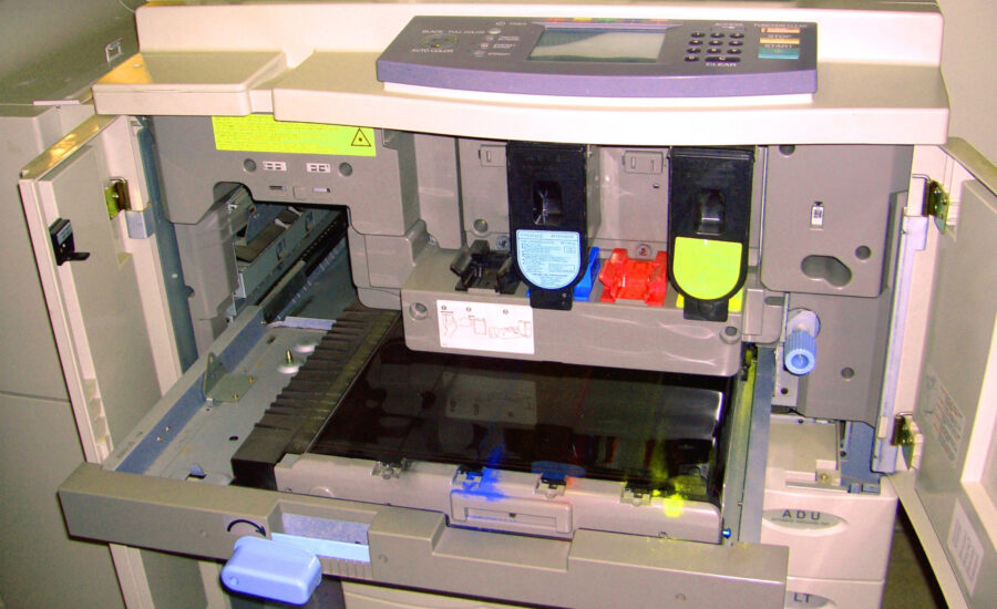 Open office photocopier during maintenance with service components visible.